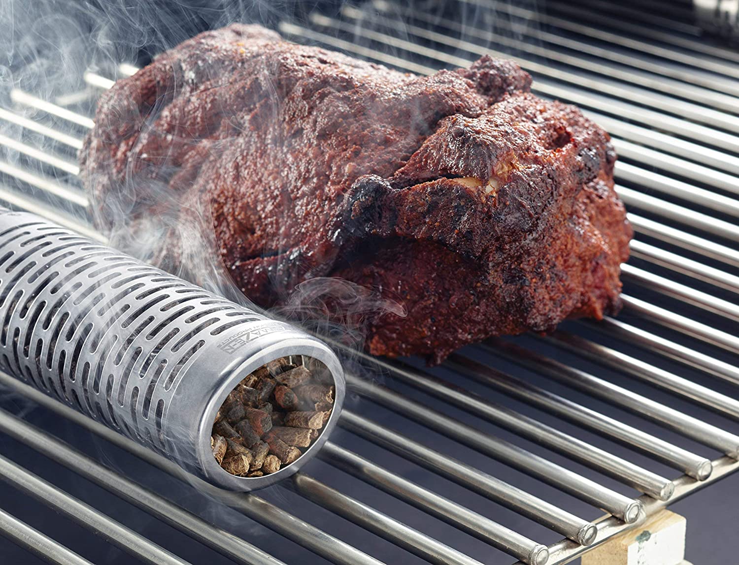 A-Maze-N Oval Pellet Tube Smoker Beside a Steak on a Grill