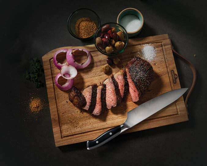Napoleon Premium Cutting Board with Knife and Steak on it