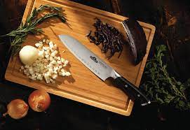 Napoleon Santoku Knife Placed on Chopping Board with Onions