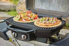 Napoleon TravelQ Pro 285 with Scissor Cart Black Gas Grill with Two Pizza on Top of the Grill